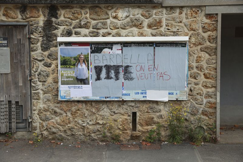 Electoral posters, some defaced with graffiti reading "Barella, we don't want you", are seen Tuesday, July 2, 2024 in Gazeran, south of Paris. The far-right National Rally, under party president Jordan Bardella, secured the most votes in the first round of the surprise legislative elections on June 30 but not enough to claim overall victory. (AP Photo/Aurelien Morissard)