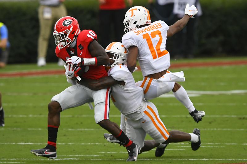 Georgia wide receiver Kearis Jackson (10) makes a catch as Tennessee defensive back Trevon Flowers (1) and defensive back Shawn Shamburger (12) defend during the first half Saturday, Oct. 10, 2020, at Sanford Stadium in Athens. (John Amis/For the AJC)