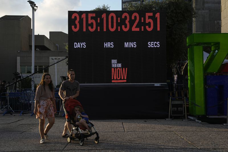 A digital counter displays the days and hours that hostages taken on Oct. 7, 2023 in southern Israel have spent in Hamas captivity in the Gaza Strip, in Tel Aviv, Israel, Saturday, Aug. 17, 2024. (AP Photo/Tsafrir Abayov)