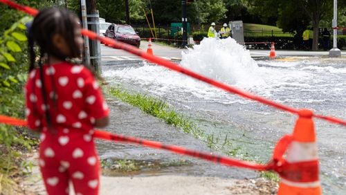 April Woods, 4, watches a water main break at Joseph E. Boone Boulevard and James P. Brawley Drive in Atlanta on May 31, 2024. (Arvin Temkar/The Atlanta Journal-Constitution/TNS)