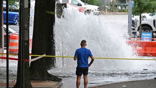 Joe Greene watches a water main break Saturday, June 1, 2024, in Atlanta. City officials were slowly repressuring the city's water system Saturday after corroding water pipes burst in downtown and Midtown, forcing many businesses and attractions to close and affecting water service in area homes. (Hyosub Shin/Atlanta Journal-Constitution via AP)