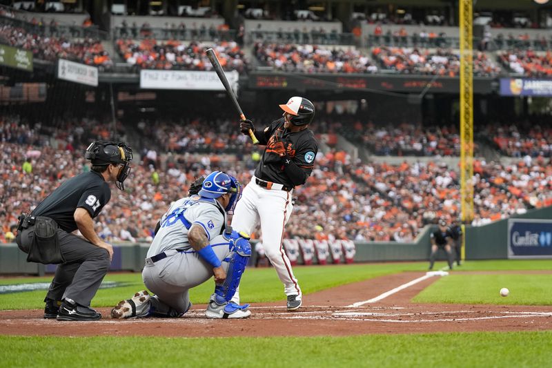 Baltimore Orioles' Jordan Westburg, right, reacts after being hit by a pitch from Kansas City Royals pitcher Seth Lugo, not visible, during the first inning in Game 2 of an AL Wild Card Series baseball game, Wednesday, Oct. 2, 2024 in Baltimore. Looking on are home plate umpire Ben May and catcher Salvador Perez. (AP Photo/Stephanie Scarbrough)