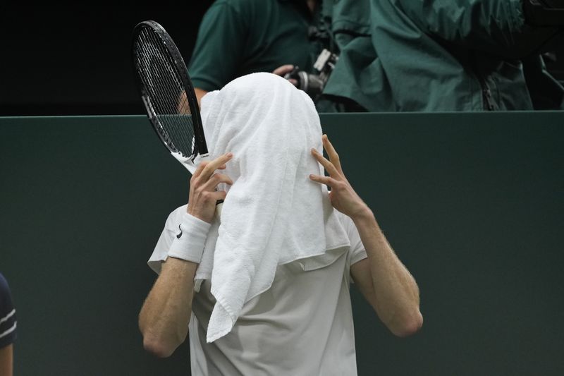 Jannik Sinner of Italy covers his face with a towel during his quarterfinal against Daniil Medvedev of Russia at the Wimbledon tennis championships in London, Tuesday, July 9, 2024. (AP Photo/Alberto Pezzali)