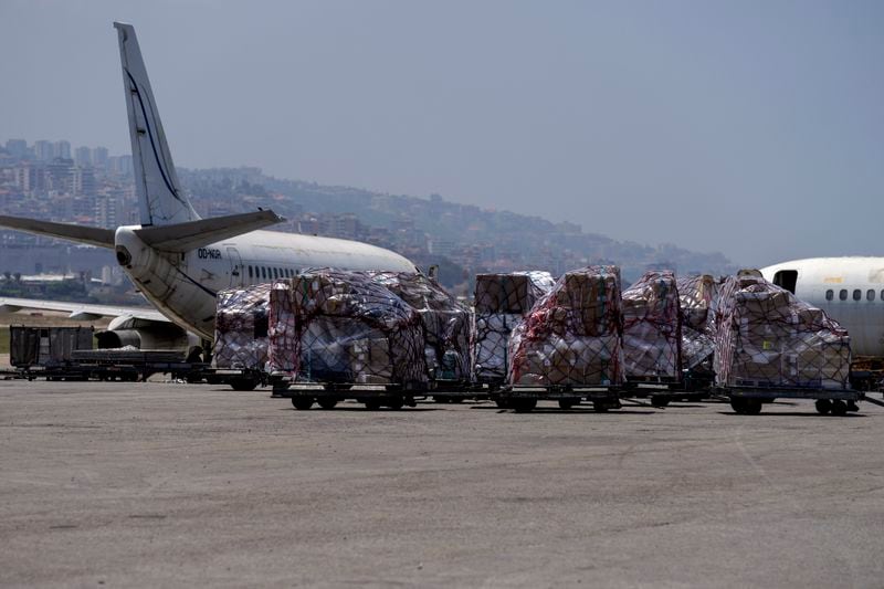 Workers unload a shipment from an airplane during a tour for journalists and diplomats at the Rafik Hariri International Airport in Beirut, Lebanon, Monday, June 24, 2024. The tour comes a day after a British newspaper published a story, citing anonymous airport workers, claiming that Hezbollah is storing weapons at the airport, as monthslong clashes with the Israeli military on the Lebanon-Israel border have significantly escalated in recent weeks. (AP Photo/Bilal Hussein)