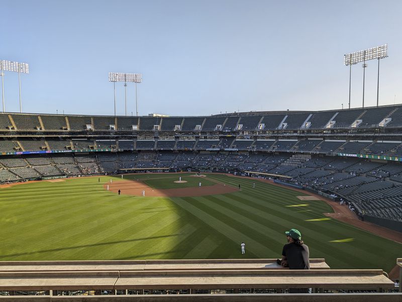 A fan standing in left field during a sparsely attended game between the Oakland A's and Colorado Rockies, May 22, 2024, at the Oakland Coliseum in Oakland, Calif. (AP Photo/Michael Liedtke)