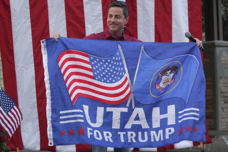 Trent Staggs carries a "Utah For Trump flag" during a rally on June 14, 2024, in Orem, Utah. Staggs waved a "Utah for Trump" flag at a recent campaign rally in his latest reminder to Utah voters that he's backed by the former president in the race to replace U.S. Sen. Mitt Romney. (AP Photo/Rick Bowmer)