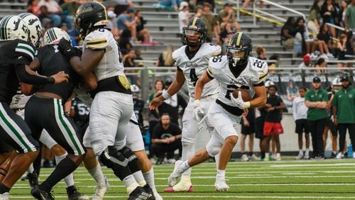 Ian Hulbert, running back for Sprayberry High School, takes a handoff and runs the ball for a touchdown during the Sprayberry at Kennesaw Mountain high school football game in Kennesaw, GA on August 30, 2024. (Jamie Spaar for the Atlanta Journal Constitution)