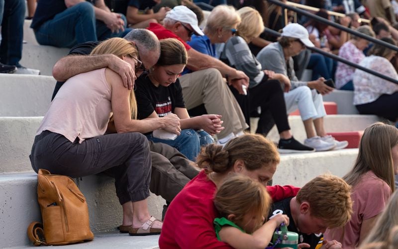 Families bow their heads in prayer Sunday at Flowery Branch High School during a celebration of the life of Ricky Aspinwall II, one of the teachers killed at Apalachee High School. (Ben Hendren for The Atlanta Journal-Constitution)