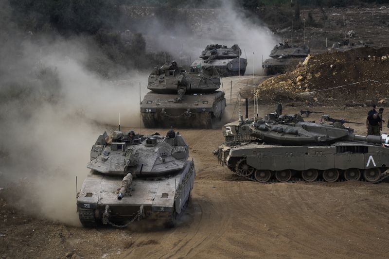 Israeli army tanks manoeuvre in a staging area in northern Israel near the Israel-Lebanon border, Tuesday, Oct. 1, 2024. (AP Photo/Baz Ratner)