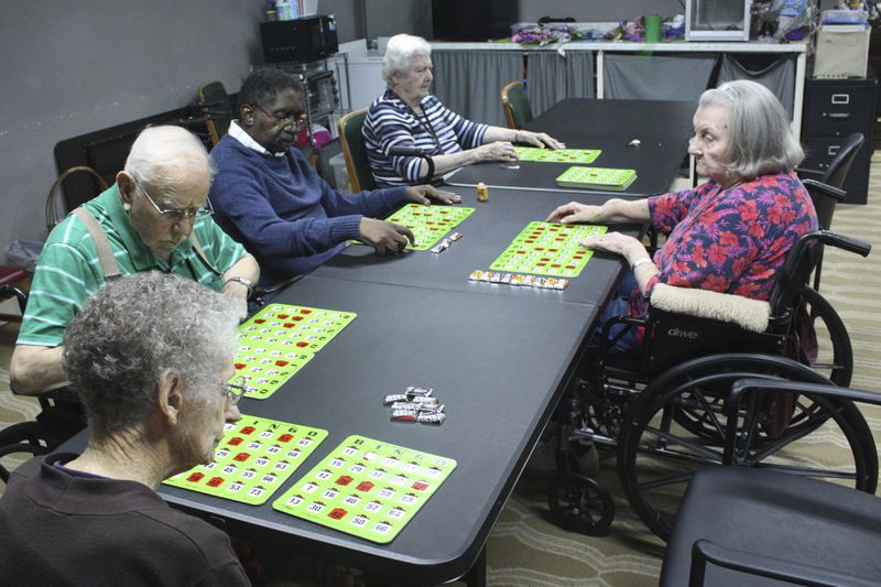 Eberline Nugent, left, Johnny Griffin, Jay Cossey, Carrie Dickson and Joyce Schiessl play bingo during activity time at The Retreat at Kenwood assisted living facility in Texarkana, Texas on Friday, May 17, 2024. Cossey's church community urged the 70-year-old to move in, though his family in Alabama has pushed for him to come live with them. (AP Photo/Mallory Wyatt)