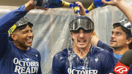 Kansas City Royals shortstop Bobby Witt Jr., center has champagne poured on him by teammates during the celebration in the locker room after a baseball game against the Atlanta Braves, Friday, Sept. 27, 2024, in Atlanta. (AP Photo/Jason Allen)