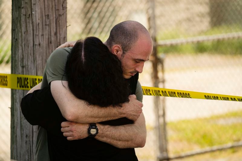 People embrace near the scene of a fatal shooting at Delaware County Linen in Chester, Pa., Wednesday, May 22, 2024. Authorities say a former employee armed with a handgun opened fire at a linen company in a Philadelphia suburb, killing multiple people and wounding three others. (AP Photo/Matt Rourke)