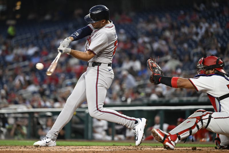 Atlanta Braves' Matt Olson, left, hits a RBI double in front of Washington Nationals catcher Keibert Ruiz during the third inning of a baseball game, Tuesday, Sept. 10, 2024, in Washington. (AP Photo/John McDonnell)