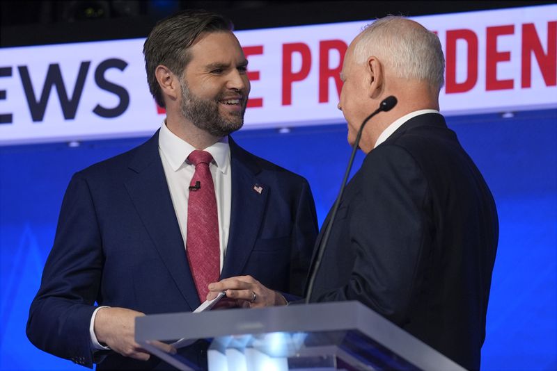 Republican vice presidential nominee Sen. JD Vance, R-Ohio, talks with Democratic vice presidential candidate Minnesota Gov. Tim Walz after the vice presidential debate hosted by CBS News Tuesday, Oct. 1, 2024, in New York. (AP Photo/Matt Rourke)