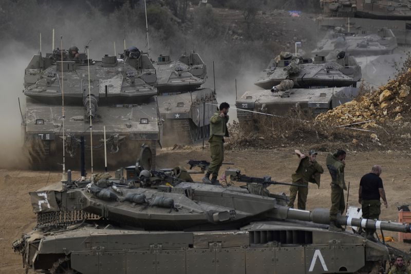 Israeli army tanks manoeuvre in a staging area in northern Israel near the Israel-Lebanon border, Tuesday, Oct. 1, 2024. (AP Photo/Baz Ratner)