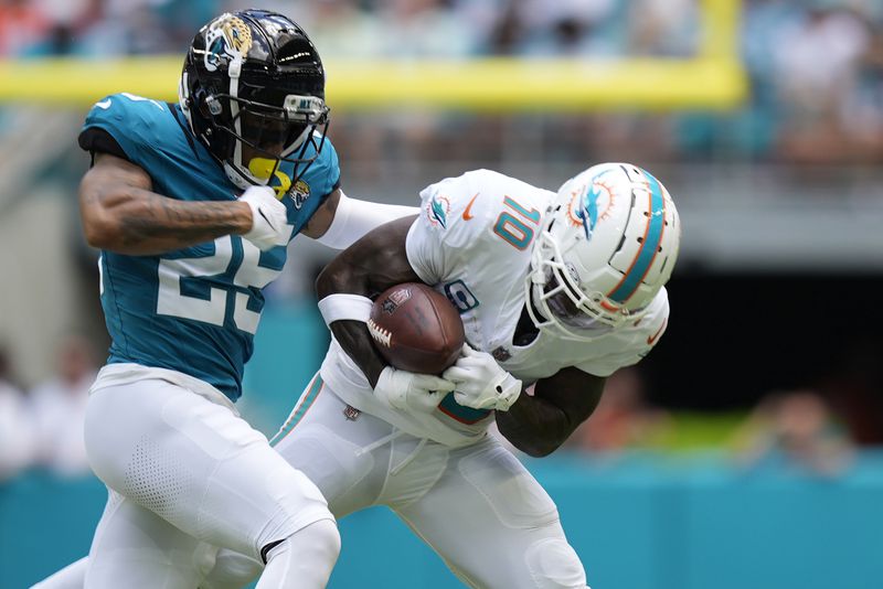 Jacksonville Jaguars cornerback Ronald Darby (25) defends Miami Dolphins wide receiver Tyreek Hill (10) during the first half of an NFL football game, Sunday, Sept. 8, 2024, in Miami Gardens, Fla. (AP Photo/Rebecca Blackwell)