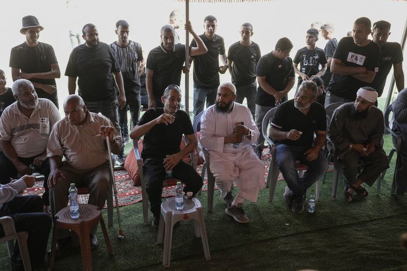 Qaid Farhan Alkadi, 52, 3rd left, who was held hostage by Hamas militants in Gaza Strip, meets his relatives and friends after arriving in the Khirbet Karkur village, near Rahat, southern Israel, Wednesday, Aug. 28, 2024. (AP Photo/Mahmoud Illean)