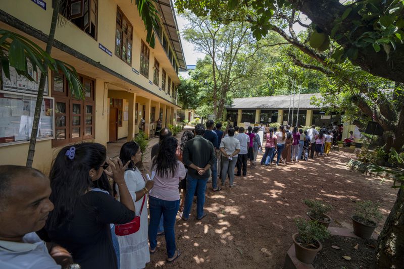 People wait in a queue to cast their votes at a polling center during the presidential election on the outskirts of Colombo , Sri Lanka Saturday, Sept. 21, 2024.(AP Photo/Rajesh Kumar Singh)