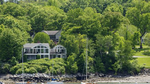 The homes of Lisa Gorman, front, and Amelia and Arthur Bond are seen, Tuesday, June 4, 2024, in Camden, Maine. The Bond's, a wealthy politically connected Missouri couple poisoned their neighbor's trees to secure a view of Camden Harbor, outraging residents in the seaside community.(AP Photo/Robert F. Bukaty)