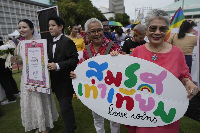 FILE - Participants hold posters celebrating equality in marriage during the Pride Parade in Bangkok, Thailand, on June 1, 2024. Thailand’s Senate voted overwhelmingly on Tuesday, June 18, 2024 to approve a marriage equality bill, clearing the last legislative hurdle for the country to become the first in Southeast Asia to enact such a law. (AP Photo/Sakchai Lalit,File)