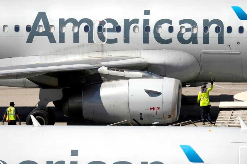 Airline employees prepare to unload a jet at Sky Harbor International Airport, Tuesday, Sept. 3, 2024, in Phoenix. (AP Photo/Matt York)