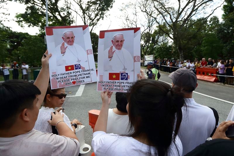 People wait for Pope Francis to arrive outside St Theresa's Home in Singapore, Friday, Sept. 13, 2024. (AP Photo/Suhaimi Abdullah)