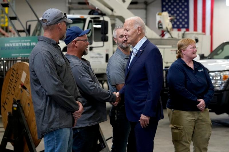 President Joe Biden, second from right, greets workers from Dairyland Power Cooperative and Vernon Electric Cooperative during a visit to Vernon Electric in Westby, Wis., Thursday, Sept. 5, 2024. Biden is in Wisconsin to promote his Investing in America agenda. (AP Photo/Susan Walsh)