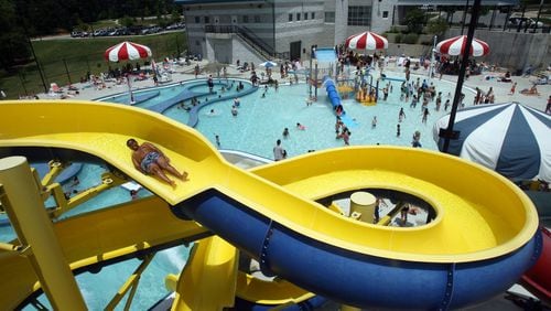 A visitor goes down the open water slide at the outdoor leisure pool at Mountain Park Aquatic Center in Stone Mountain.