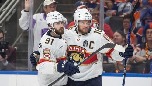 Florida Panthers' Oliver Ekman-Larsson (91) and Aleksander Barkov (16) celebrate after a goal against the Edmonton Oilers during the third period of Game 6 of the NHL hockey Stanley Cup Final, Friday, June 21, 2024, in Edmonton, Alberta. (Jason Franson/The Canadian Press via AP)