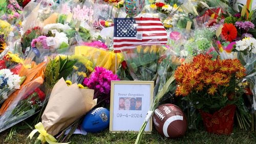 A memorial with images of the those killed are, from left, Richard "Ricky" Aspinwall, Cristina Irimie, Mason Schermerhorn and Christian Angulo at a memorial at Apalachee High School on Friday in Winder. (Jason Getz/The Atlanta Journal-Constitution)