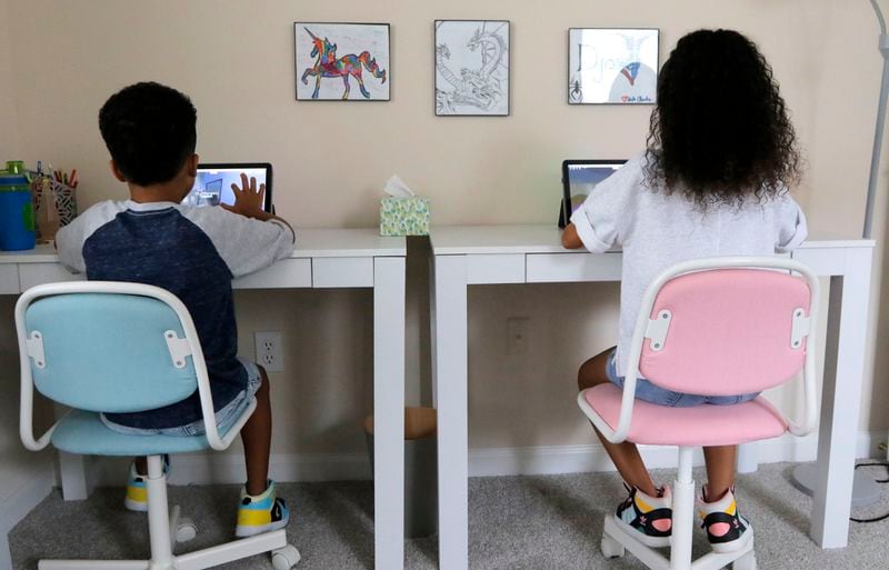 Ayra Murphy plays a computer game on a tablet with her brother Djoser Murphy at her home in Suwanee on Monday, July 12, 2021. Ayra Murphy was placed in a gifted education program two years ago at Sycamore Elementary. (Christine Tannous / christine.tannous@ajc.com)
