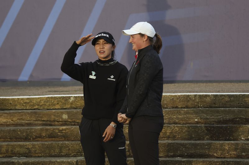 Lydia Ko, of New Zealand, left, the new Champions golfer gestures with Lottie Woad the leading amateur during presentation ceremony for the Women's British Open golf championship, in St. Andrews, Scotland, Sunday, Aug. 25, 2024. (AP Photo/Scott Heppell)