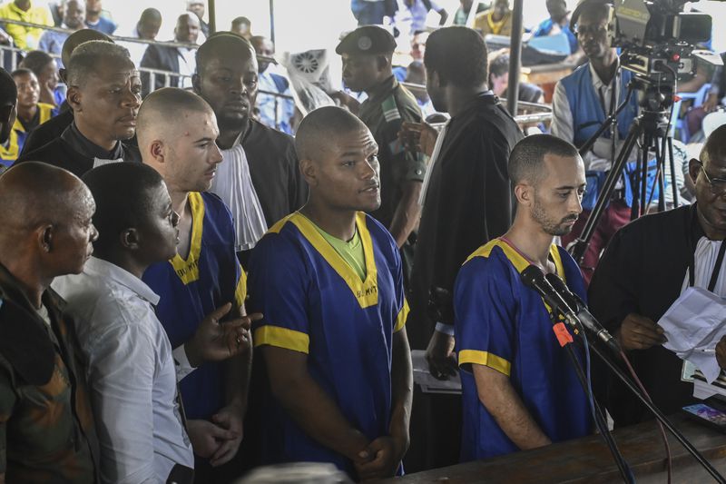 From left T,yler Thompson Jr, Marcel Malanga and Benjamin Reuben Zalman-Polun, all American citizens, face the court in Kinshasa with 52 other defendants Friday June 7, 2024, accused of a role in last month's attempted coup in Congo led by little-known opposition figure Christian Malanga in which six people were killed. (AP Photo/Samy Ntumba Shambuyi)