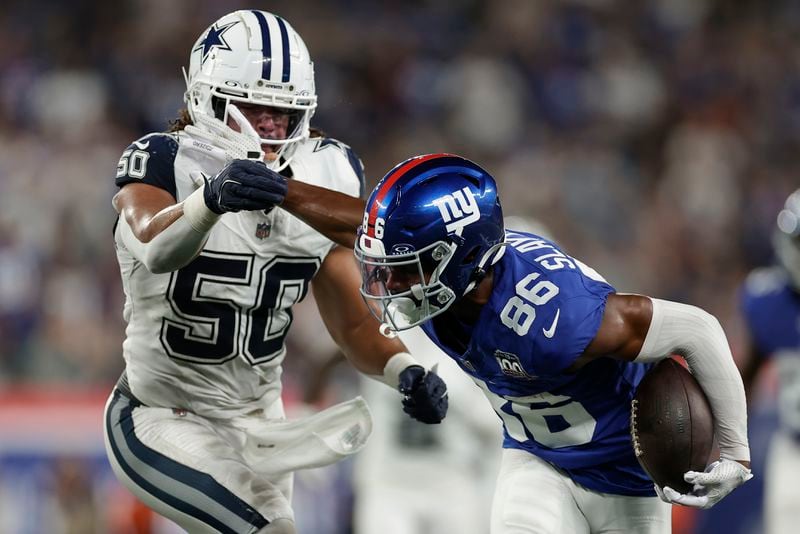 New York Giants wide receiver Darius Slayton (86) stiff arms Dallas Cowboys linebacker Eric Kendricks (50) during the first quarter of an NFL football game, Thursday, Sept. 26, 2024, in East Rutherford, N.J. (AP Photo/Adam Hunger)