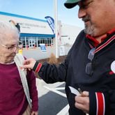 Bill Stephens places a sticker on the vest of his 95-year-old mother, Arline Stephens, after both cast their votes in Gwinnett County during the first day of early voting in the Georgia presidential primary in February. Miguel Martinez/AJC