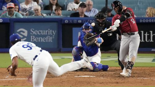 Arizona Diamondbacks' Christian Walker, right, hits a three-run home run as Los Angeles Dodgers relief pitcher Michael Petersen, left, watches along with catcher Will Smith and home plate umpire Jordan Baker during the ninth inning of a baseball game Wednesday, July 3, 2024, in Los Angeles. (AP Photo/Mark J. Terrill)
