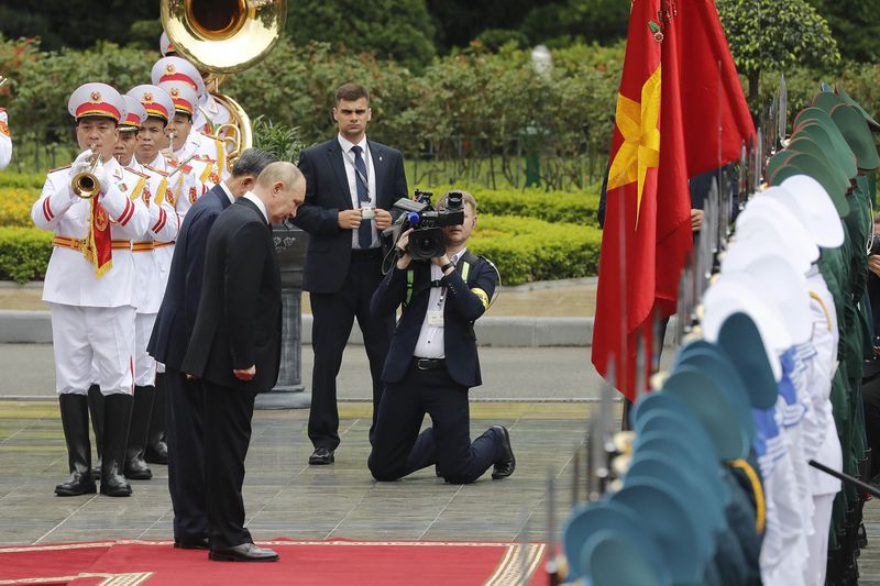 Vietnamese President To Lam, center left, and his Russian counterpart Vladimir Putin, center right, review the guard of honor at the Presidential Palace in Hanoi, Vietnam, Thursday, June 20, 2024. (AP Photo/Minh Hoang, Pool)