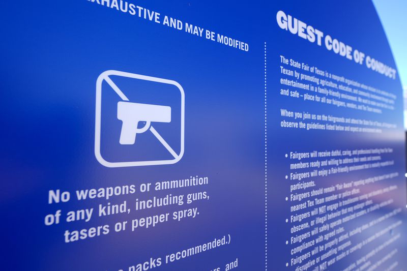 A sign by an entry point at the State Fair of Texas advises guests that no weapons are allowed on the fair grounds in Dallas, on Friday, Sept. 27, 2024. (AP Photo/Tony Gutierrez)