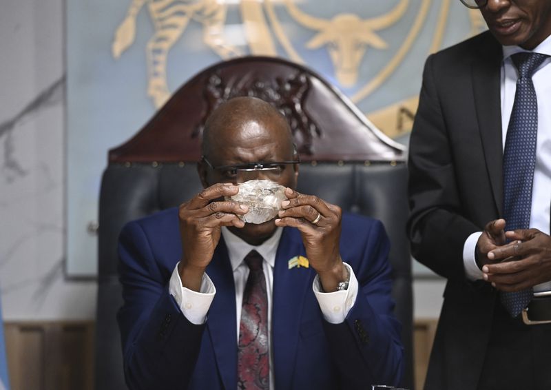 Botswana's President Mokgweetsi Masisi holds the 2,492-carat diamond that was unearthed at one of its mines and will be put on show, Thursday, Aug. 22, 2024, in Gaborone. (AP Photo)