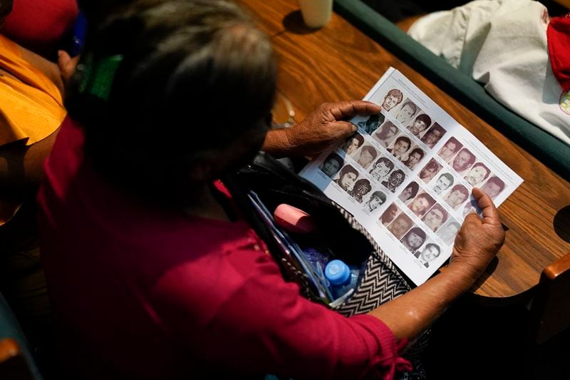 Photos of missing people fill a report by the Guerrero state government during the presentation of a new report about the country’s 1965-1990 “dirty war” by Mexico's governmental Truth Commission in Mexico City, Friday, Aug. 16, 2024. (AP Photo/Eduardo Verdugo)