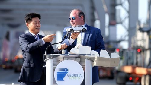 Oscar Kwon, HMGMA president and CEO, presents Kent Fountain, chairman of the Georgia Ports Authority Executive Board, with a model of an electric car during a ceremony to mark the arrival of the first shipment of equipment for the Hyundai Metaplant.