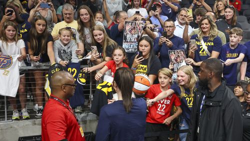 Indiana Fever guard Caitlin Clark, center, signs autographs for fans before the Fever game against the Atlanta Dream at State Farm Arena, Friday, June 21, 2024, in Atlanta. (Jason Getz / AJC)
