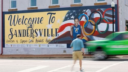 A pedestrian crosses North Harris Street in downtown Sandersville, where a mural is dedicated to Olympic gold medalist and Atlanta Dream player Allisha Gray on Tuesday, April 14, 2024. (Miguel Martinez / AJC)