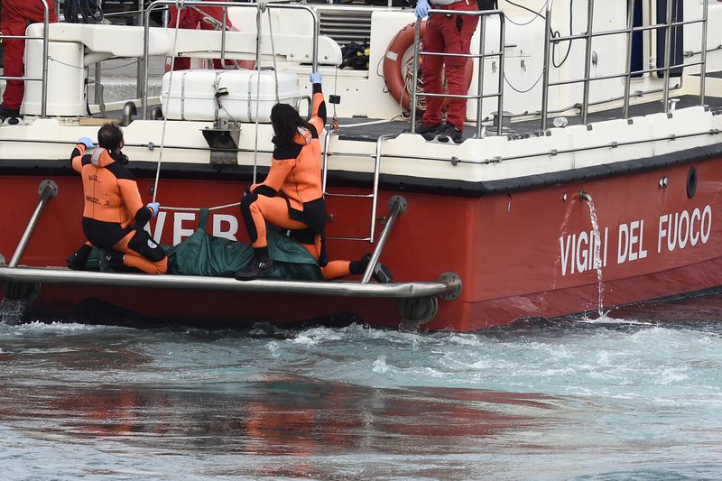 Italian Firefighters scuba divers bring ashore in a green bag the body of one of the victims of the UK flag vessel Bayesian, Wednesday, Aug. 21, 2024. The sail yacht was hit by a violent sudden storm and sunk early Monday, while at anchor off the Sicilian village of Porticello near Palermo, in southern Italy. (AP Photo/Salvatore Cavalli)