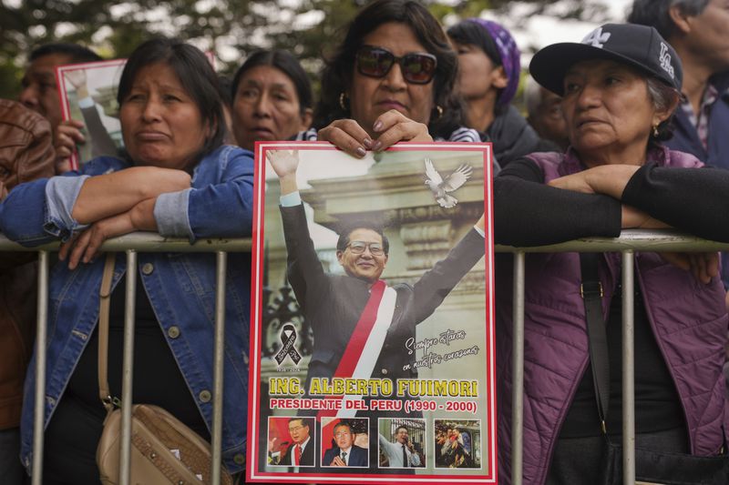 Supporters of former President Alberto Fujimori gather outside the cemetery during his funeral in Lima, Peru, Saturday, Sept. 14, 2024. (AP Photo/Guadalupe Pardo)