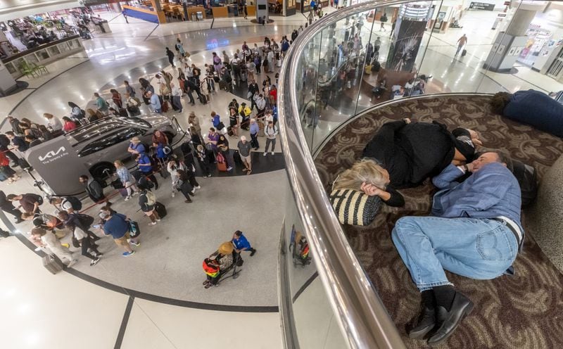 Allyn and Werner Bosch, from North Carolina, slept on the second level of the atrium as long lines and clusters of passengers sleeping on backpacks and folded blankets were spread throughout the Hartsfield-Jackson International Airport domestic terminal Monday morning, July 22, 2024. A global technology outage that hit Delta Air Lines hard led to thousands of canceled flights and passengers sleeping in airports across the world. (John Spink/AJC)