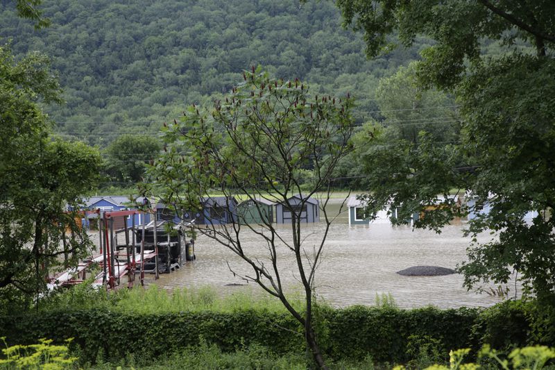 Water floods the lower level of homes, Thursday, July 11, 2024, in Bolton, Vt., near the Winooski River. (AP Photo/Hasan Jamali)