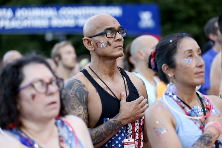 Luis Arroyo puts his hand over his heart during the National Anthem before the start of the 55th Atlanta Journal-Constitution Peachtree Road Race in Atlanta on Thursday, July 4, 2024.  (Arvin.Temkar / ajc.com)