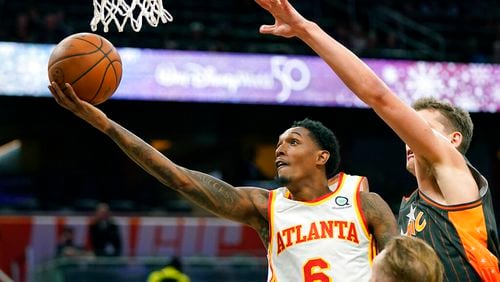 Atlanta Hawks guard Lou Williams (6) gets past Orlando Magic center Moritz Wagner, right, for a shot during the first half of an NBA basketball game, Wednesday, Dec. 15, 2021, in Orlando, Fla. (AP Photo/John Raoux)