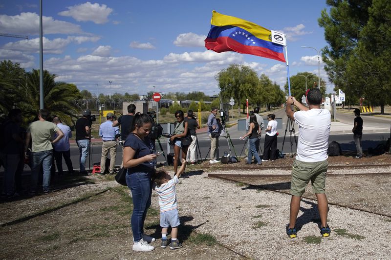 Supporters of Edmundo González wait for his arrival outside the Torrejón Air Base in Madrid, Spain, Sunday, Sept. 8, 2024. Former Venezuelan opposition presidential candidate Edmundo González has fled into exile after being granted asylum in Spain, delivering a major blow to millions who placed their hopes in his upstart campaign to end two decades of single-party rule. (AP Photo/Andrea Comas)